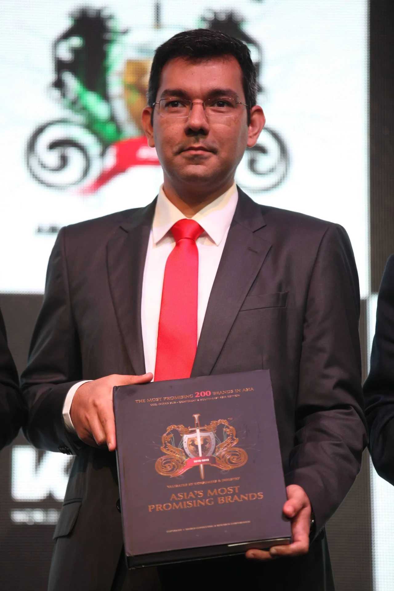 WCRC Leaders awards — Asia's Most Promising Brands coffee-table book received on stage by a KPMG representative